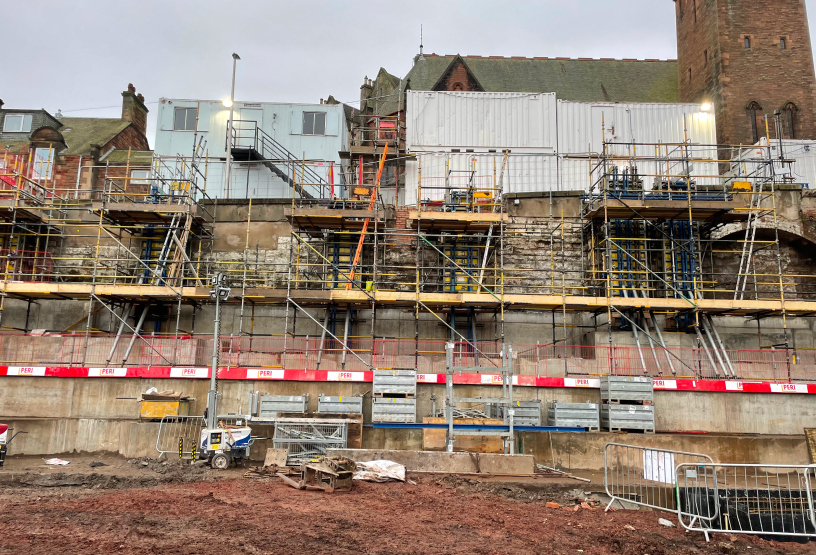 A construction site featuring a building with scaffolding installed for ongoing repair or renovation activities.