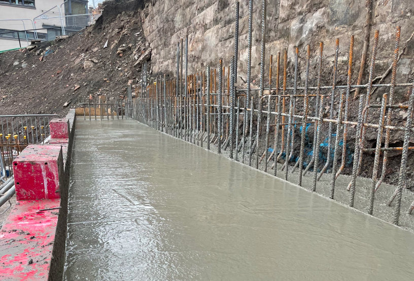 Concrete is being poured into a building, illustrating the ongoing construction process of the structure