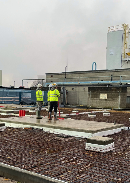 2 men stood on top of rebar on a Scottish construction site wearing PPE Hard hat, hi-vis vest and gloves