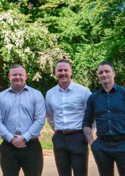 3 male management staff members standing together in office wear showcasing a collaborative work environment